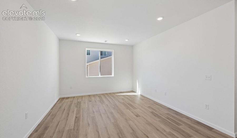 Room featuring neutral paint, wood-finish flooring, and recessed ceiling lighting