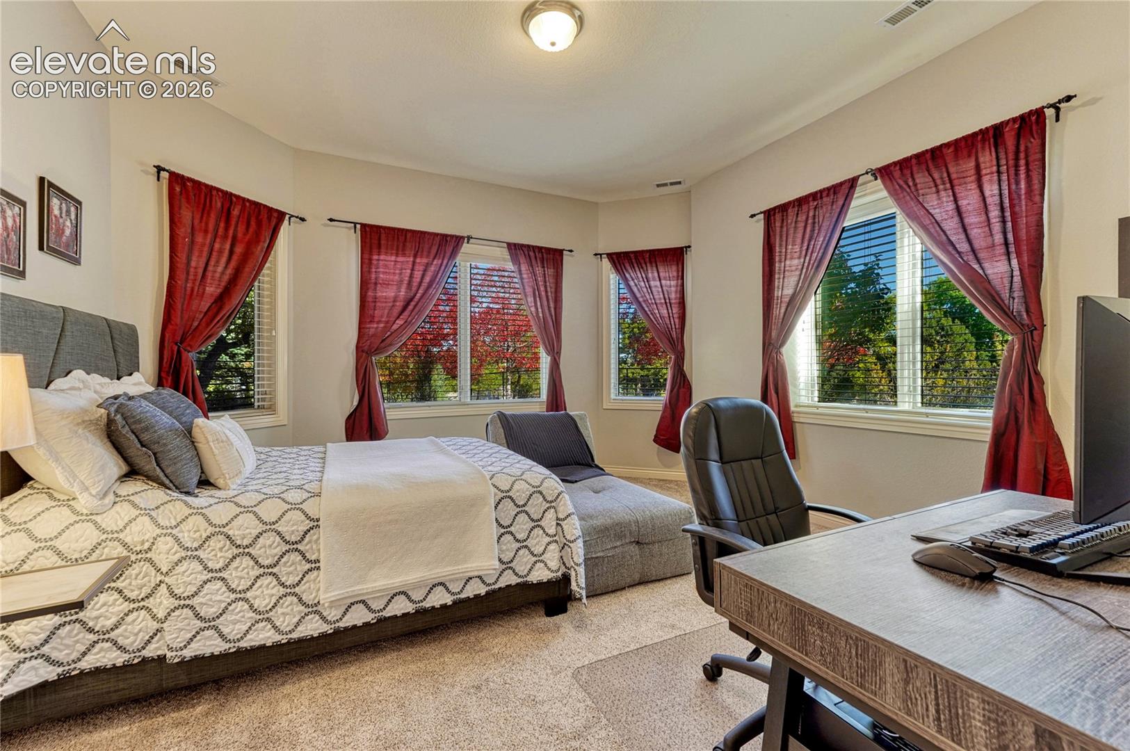 Neutral-toned room featuring a bay window configuration, wall-to-wall carpeting, and a flush-mount light fixture