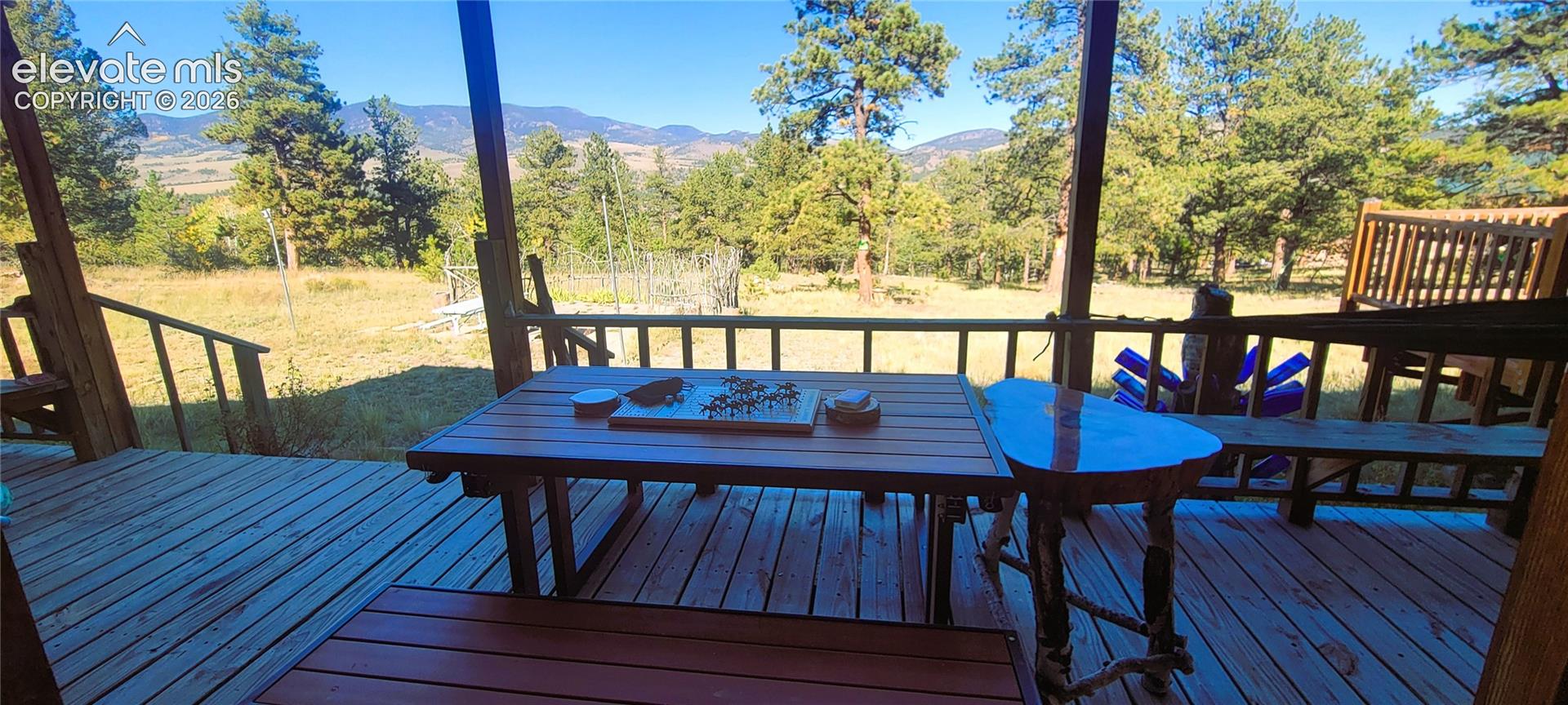 Covered outdoor deck with wood flooring and natural wood railing