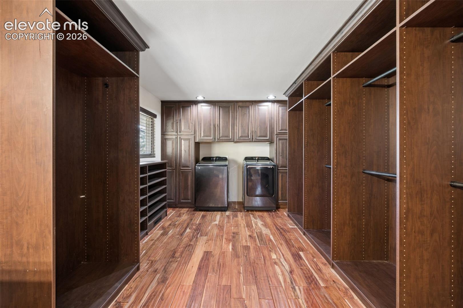 Custom built-in dark wood cabinetry, integrated open shelving, dedicated shoe storage, wood-finish flooring, and recessed ceiling lighting