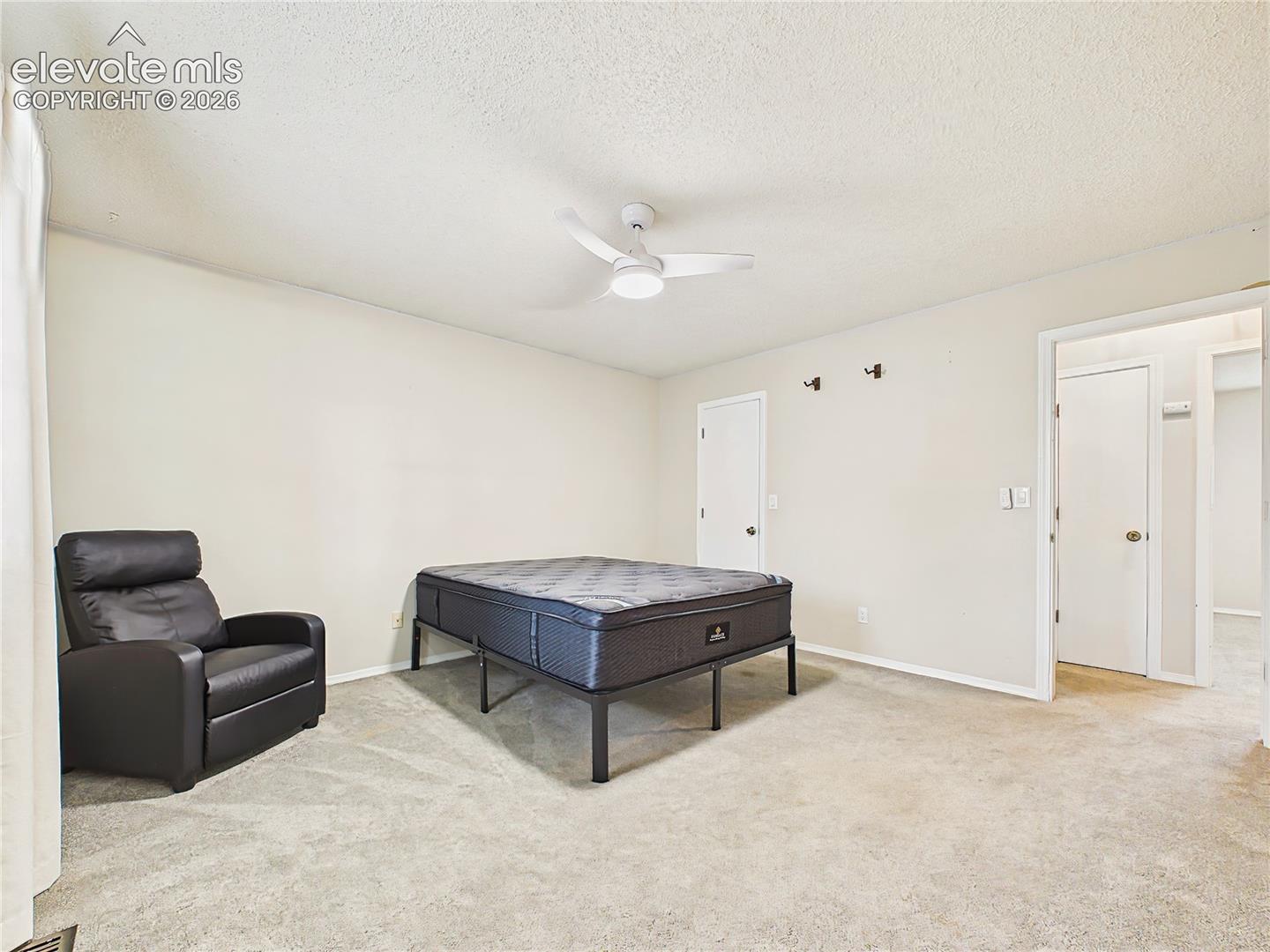 Generously sized primary bedroom with plush carpeting, neutral finishes, and plenty of room for a full bedroom suite. Up Stairs