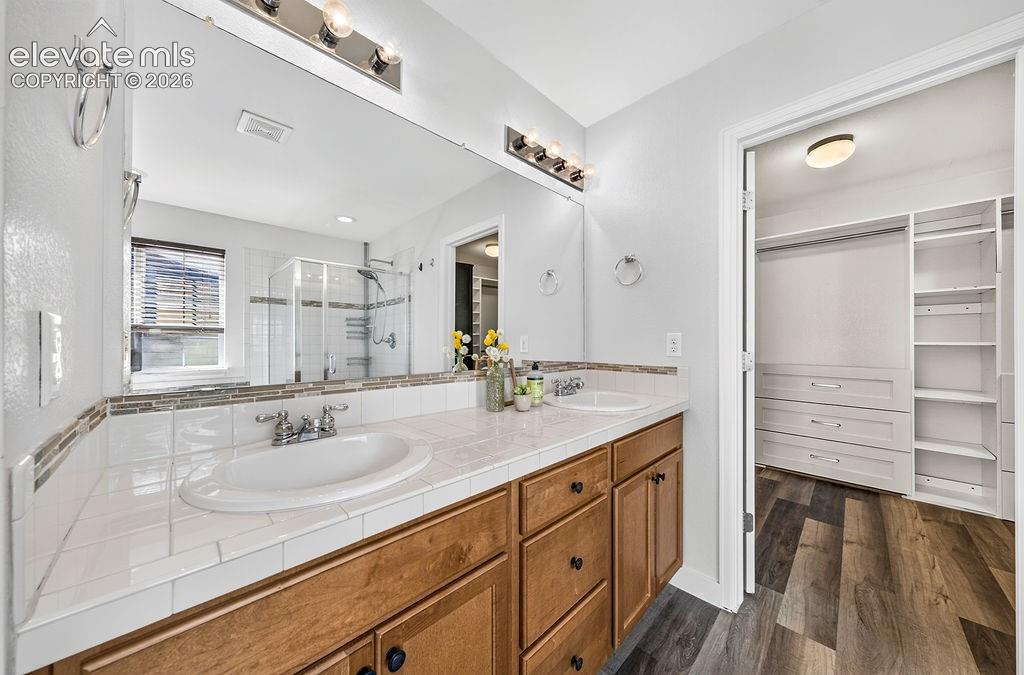 Dual vanity with tile countertops and wood cabinetry