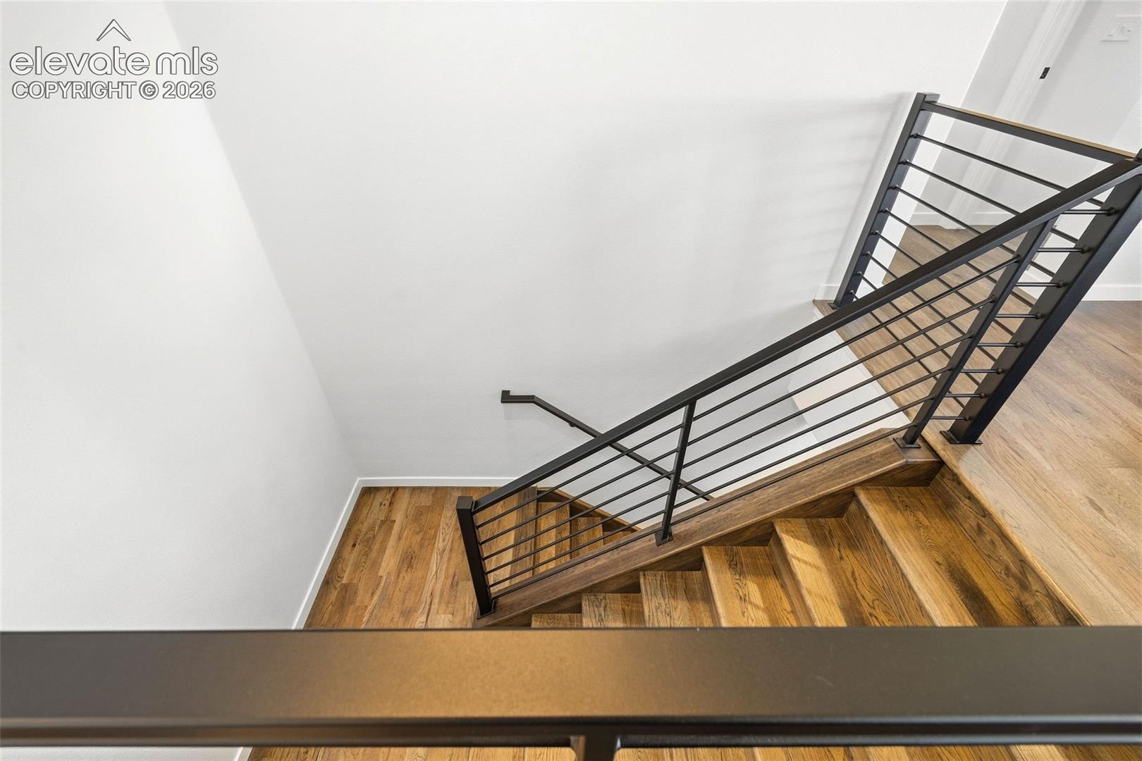 The beautiful hardwood floors continue down the stairs to the basement level. The upgraded metal stair railing adds a modern touch to the whole home. 