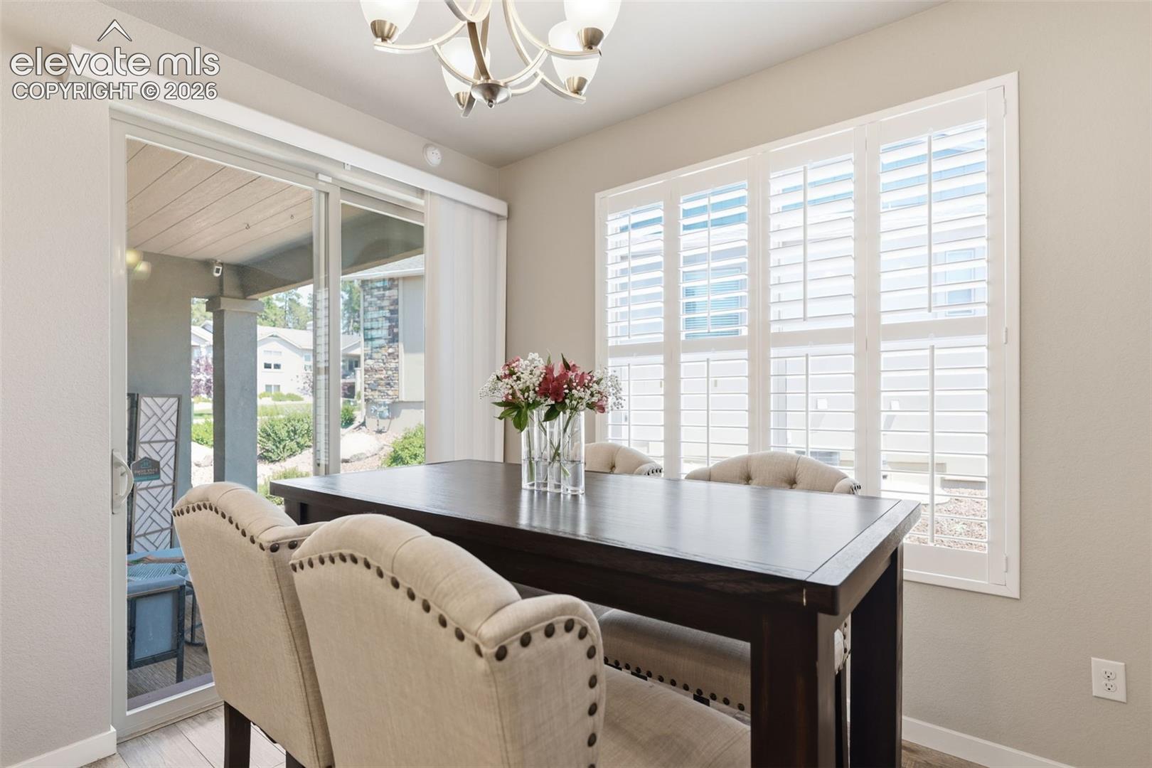 Recessed lighting, sliding glass door, plantation shutters, and light  brown luxury vinyl plank flooring.
