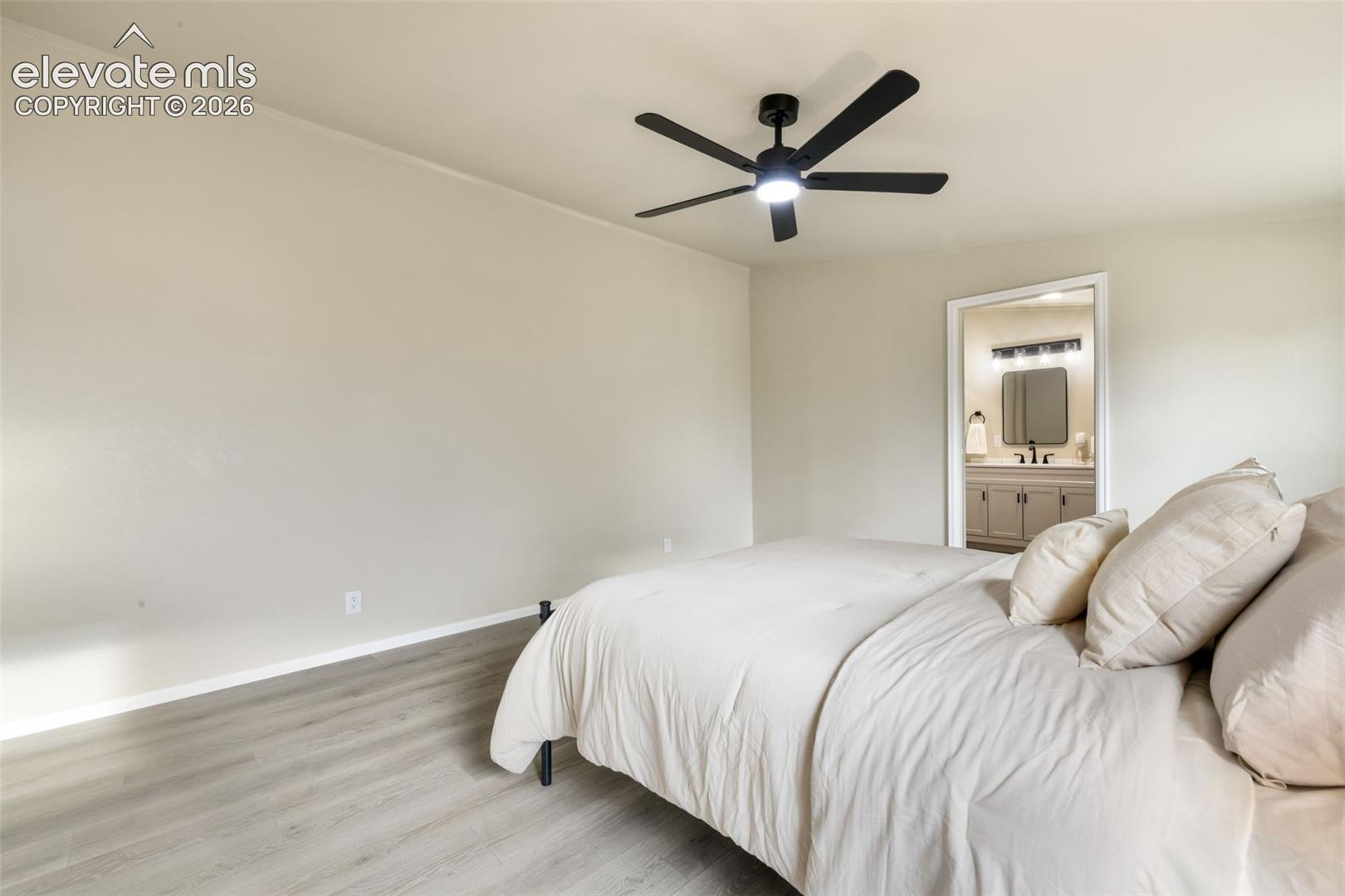 Light wood-finish flooring, a contemporary ceiling fan with integrated lighting, and neutral wall paint