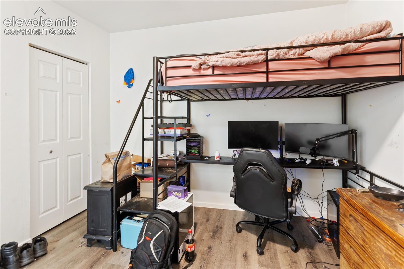 Room featuring wood-finish flooring and a bi-fold closet door