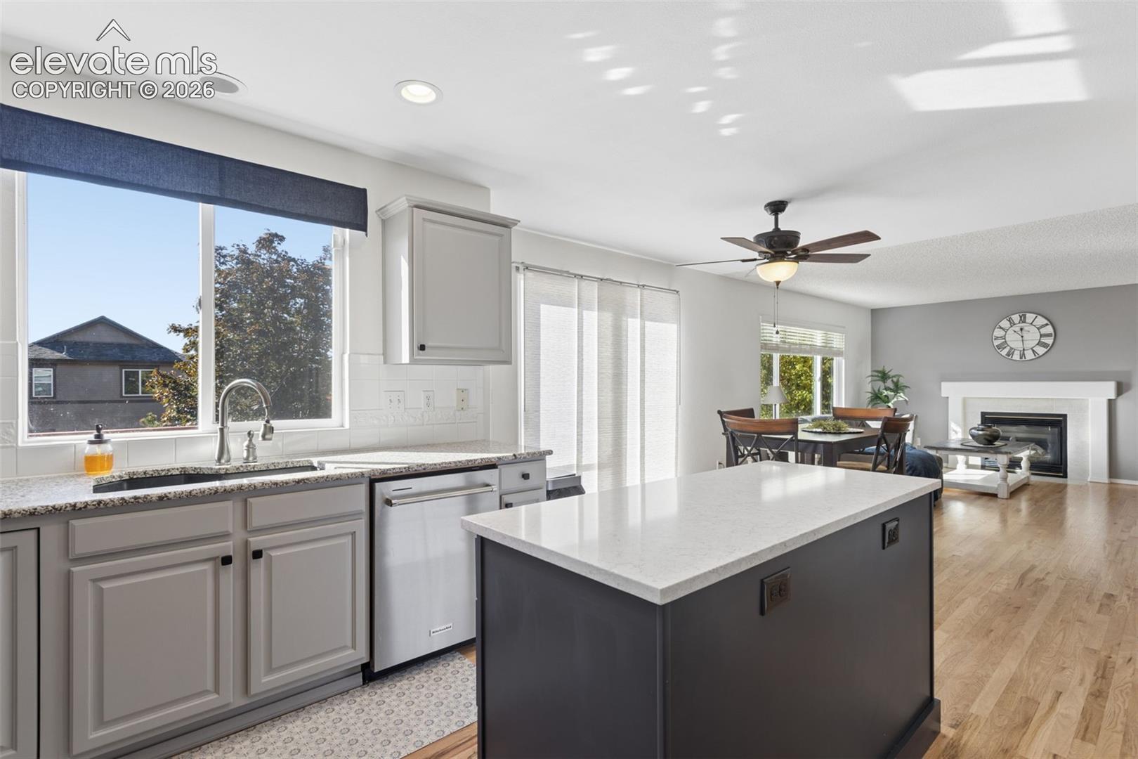Kitchen featuring a central island with a solid-surface countertops, beautiful cabinetry, under-mount kitchen sink,  stainless steel appliances, and hardwood flooring