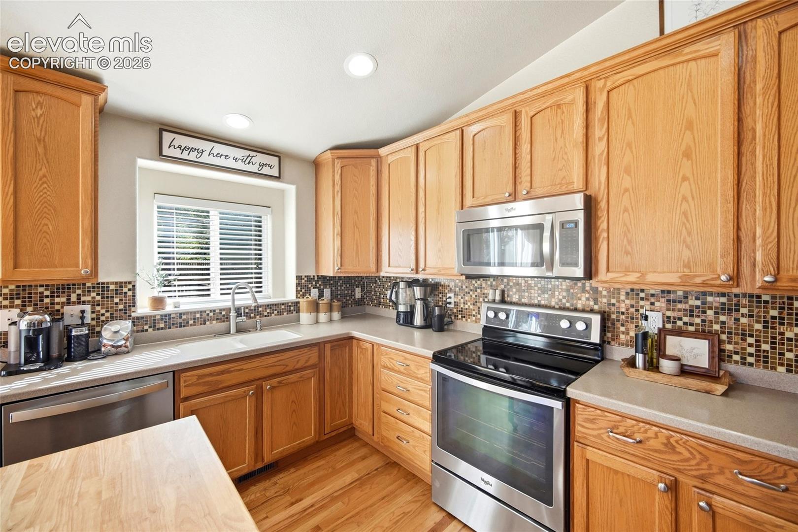 Wood-finish cabinetry paired with a tile backsplash