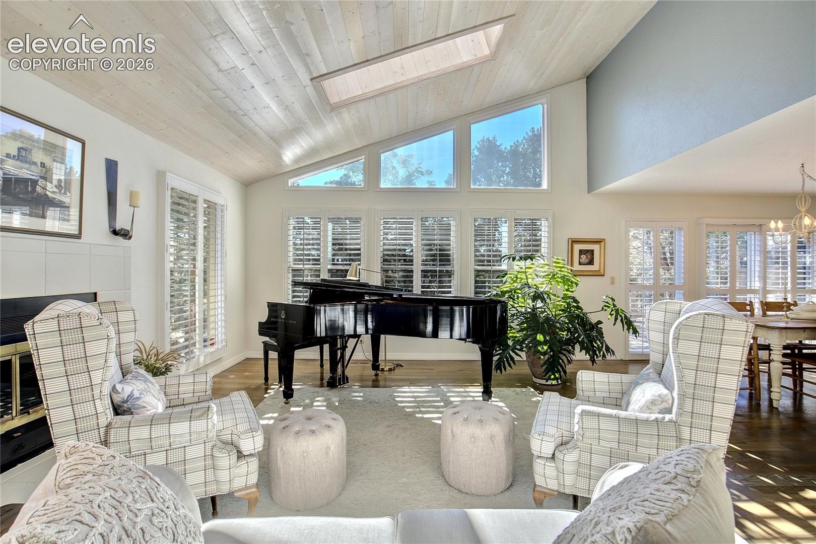 A wood-burning fireplace, gleaming hardwoods + walls of natural light bring warmth to this architecturally striking space.