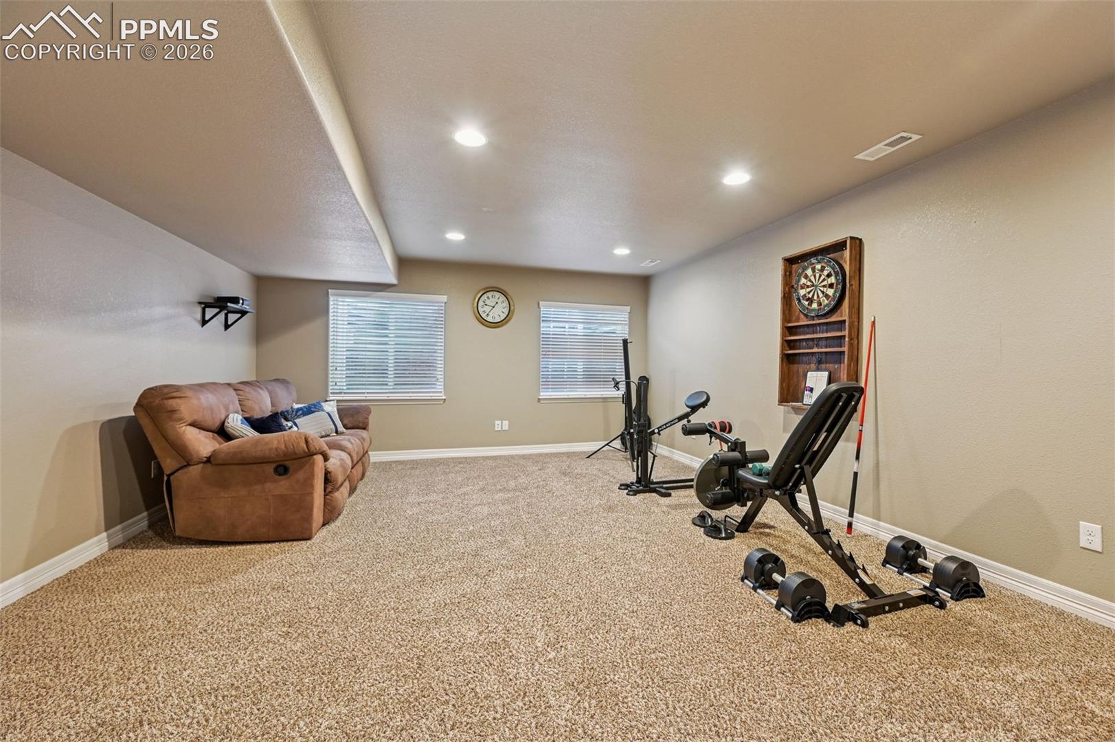 Exercise room with light carpet and recessed lighting