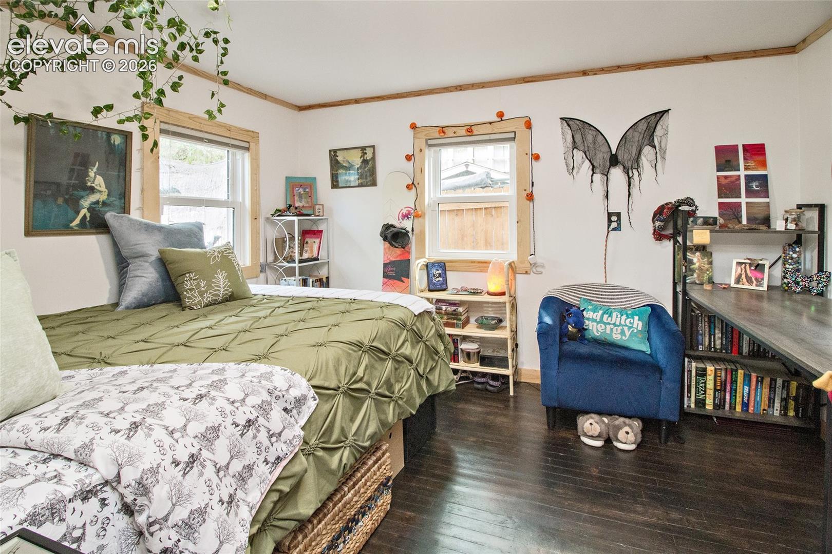 Wood-finish flooring, dual windows with natural wood trim, and a built-in shelving unit