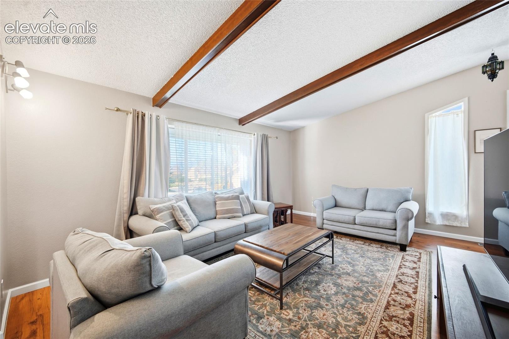LARGE LIVING ROOM, WOOD BEAMED CEILINGS AND ADJOINS THE FORMAL DINING AREA. 