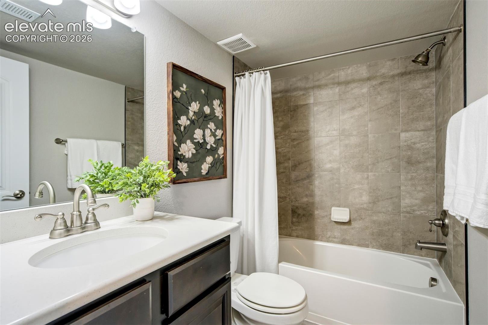 Vanity with an integrated sink, brushed nickel faucet, and dark wood-finish cabinetry