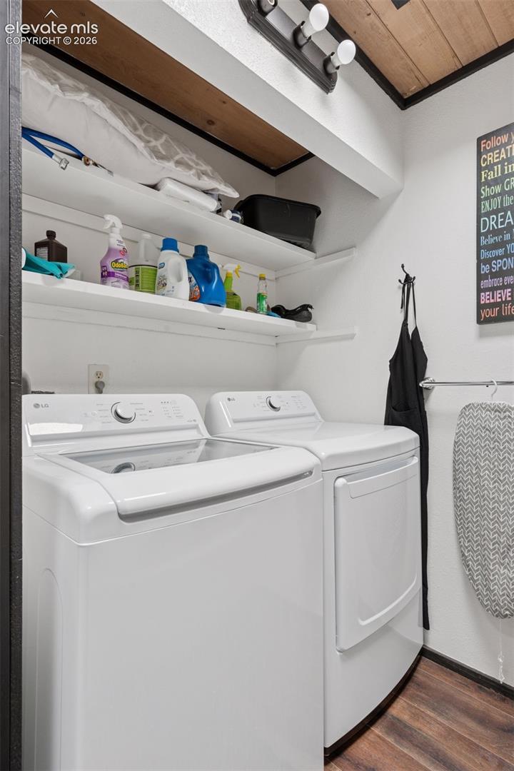 Laundry area featuring washer and dryer with built-in shelving for storage