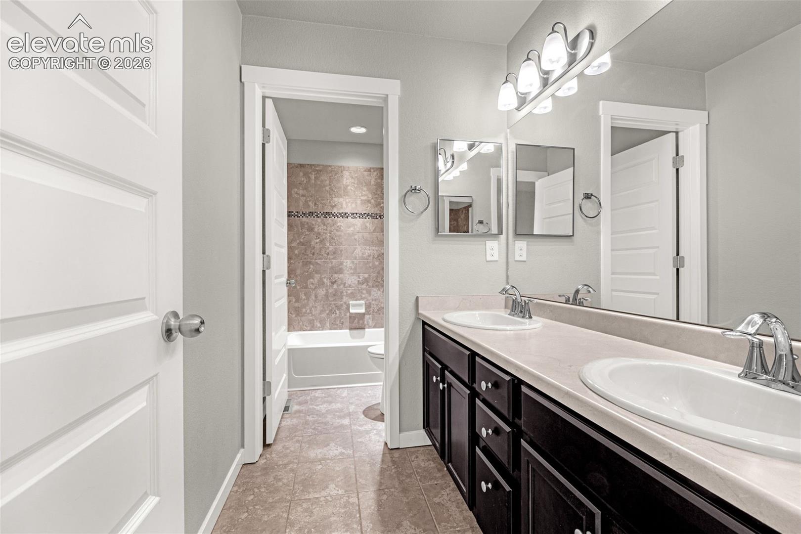 Dual vanity with undermount sinks, chrome fixtures, and a spacious mirror