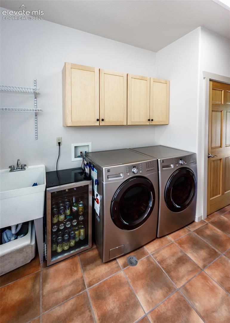 Main level laundry with built-in cabinets, sink, built-in ironing board, and a window for added light. 