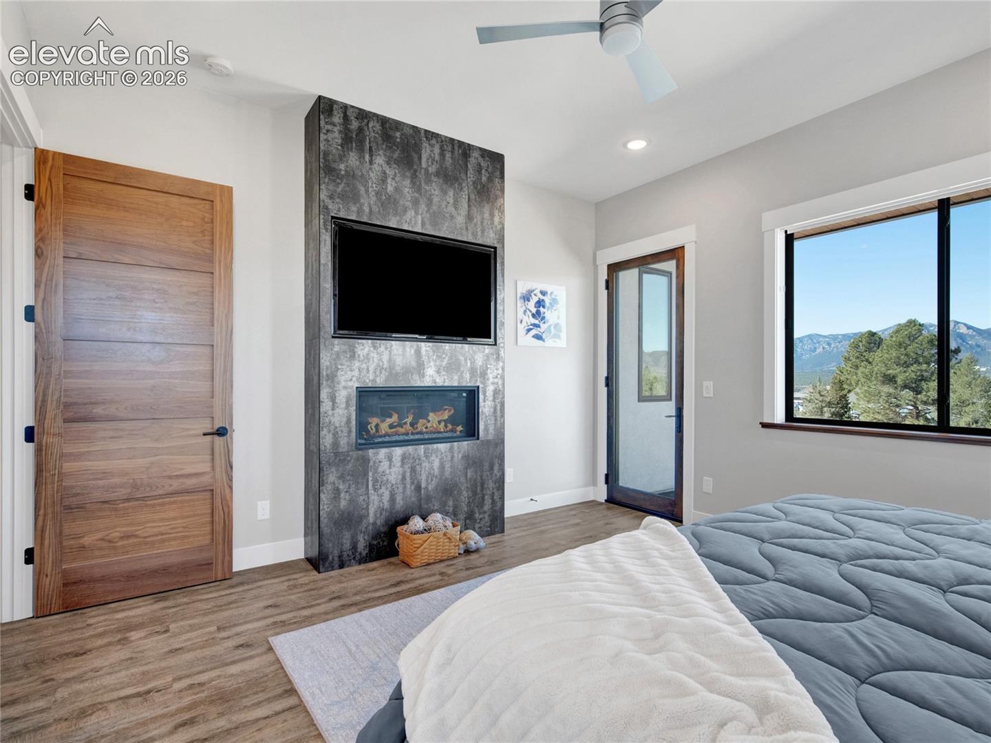 Primary bedroom with a modern ceiling fan and gas fireplace.