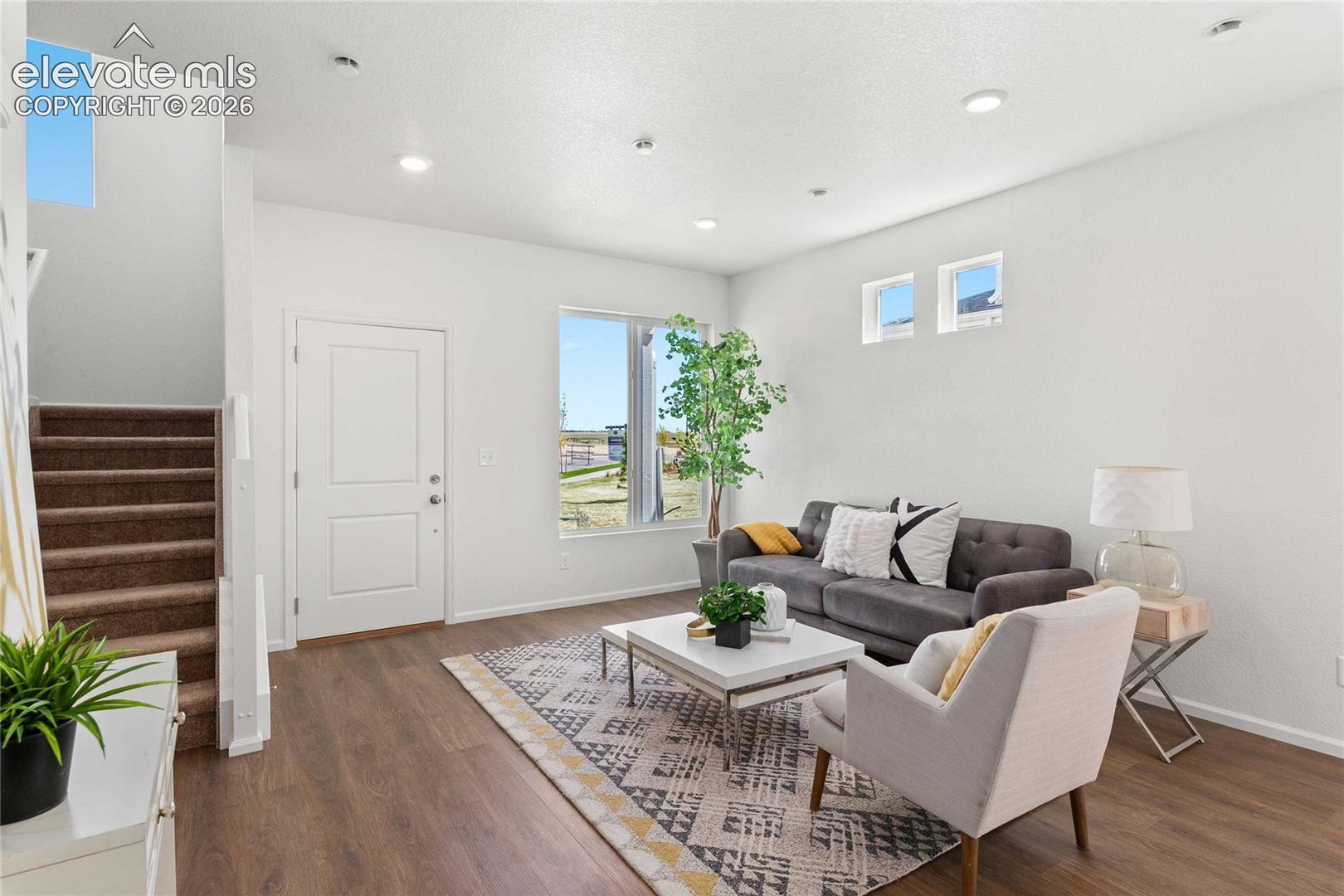 Spacious living area featuring wood-finish flooring, recessed lighting, and white walls
*photos  of a model home*