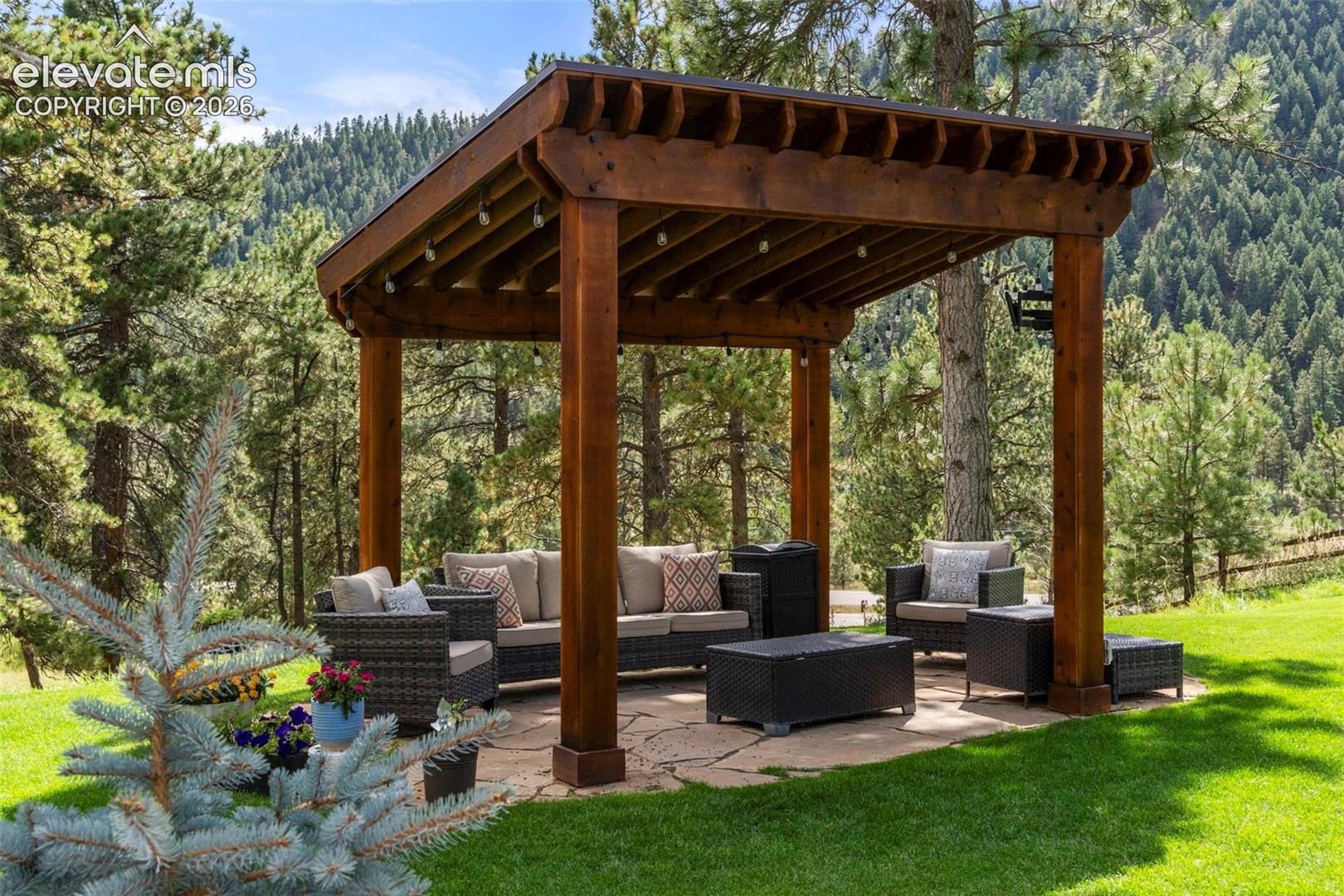 View of property's community featuring a patio area, an outdoor living space, a wooded view, and a yard