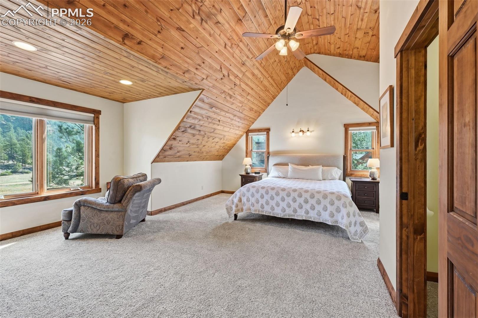The primary retreat features soaring vaulted ceilings finished with wood accents, and amplenatural lighting. 