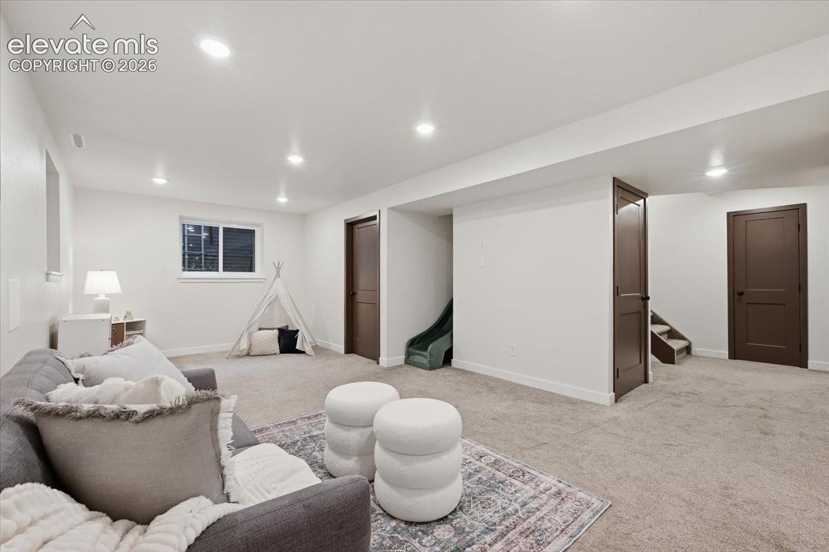 Recessed lighting throughout, light-toned carpeting, white painted walls, and a slide!