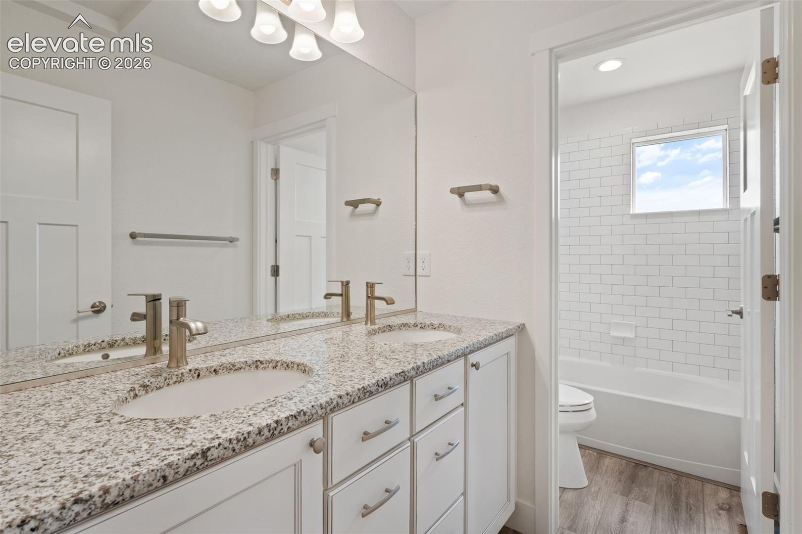 Double vanity with granite countertop, undermount sinks, and brushed nickel fixtures