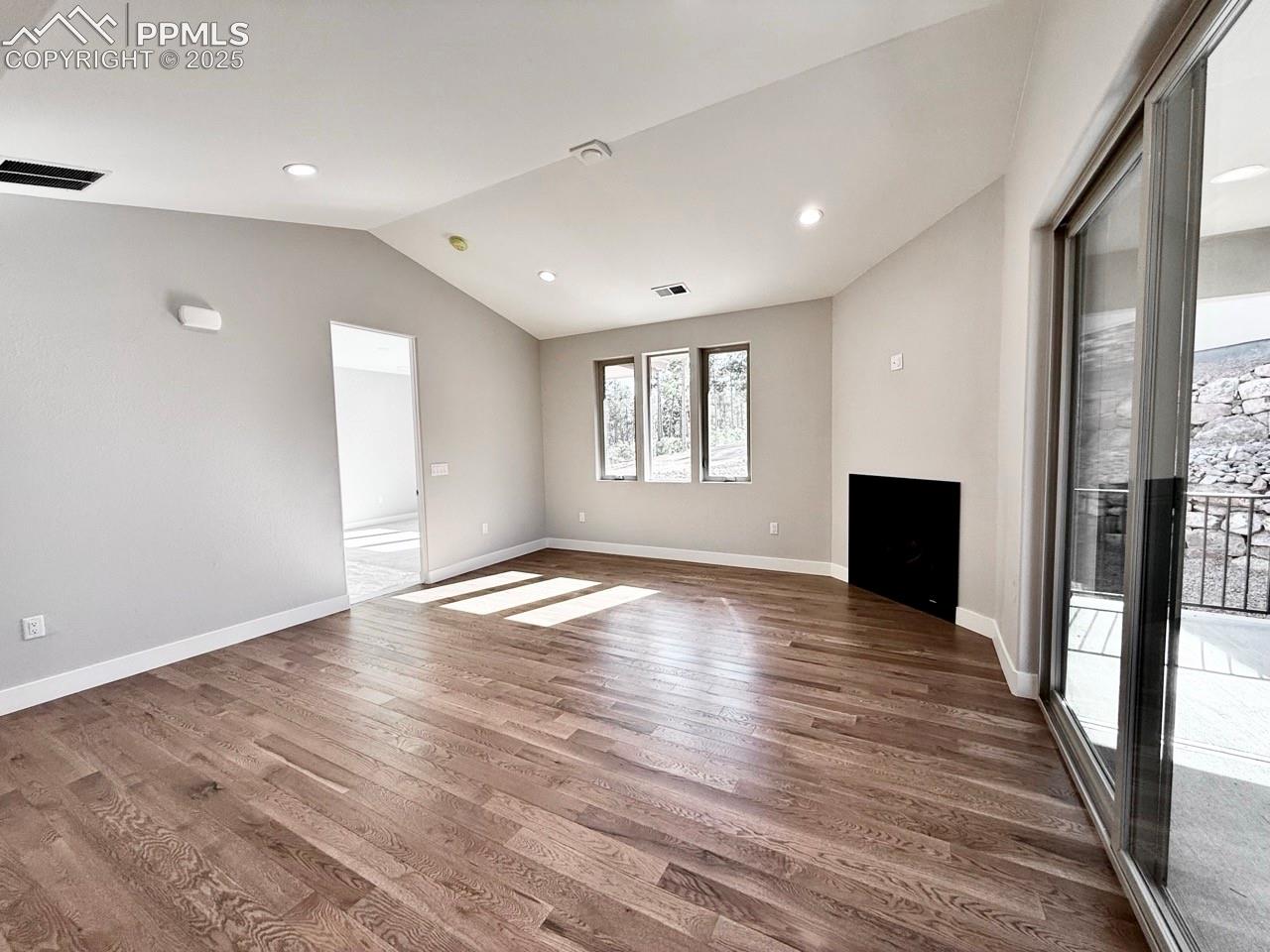 Vaulted Living Room with Gas Fireplace and Sliding Door to Covered Patio.