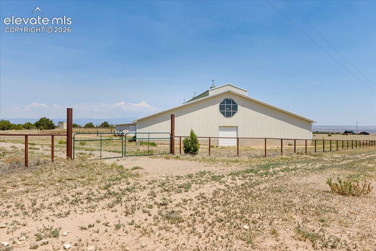 South side of building. The property road frontage and part of the north side have excellent sturdy fencing. Overhhead door in photo is 12 ft. wide and 12 ft. high. All measurements are approximate.
