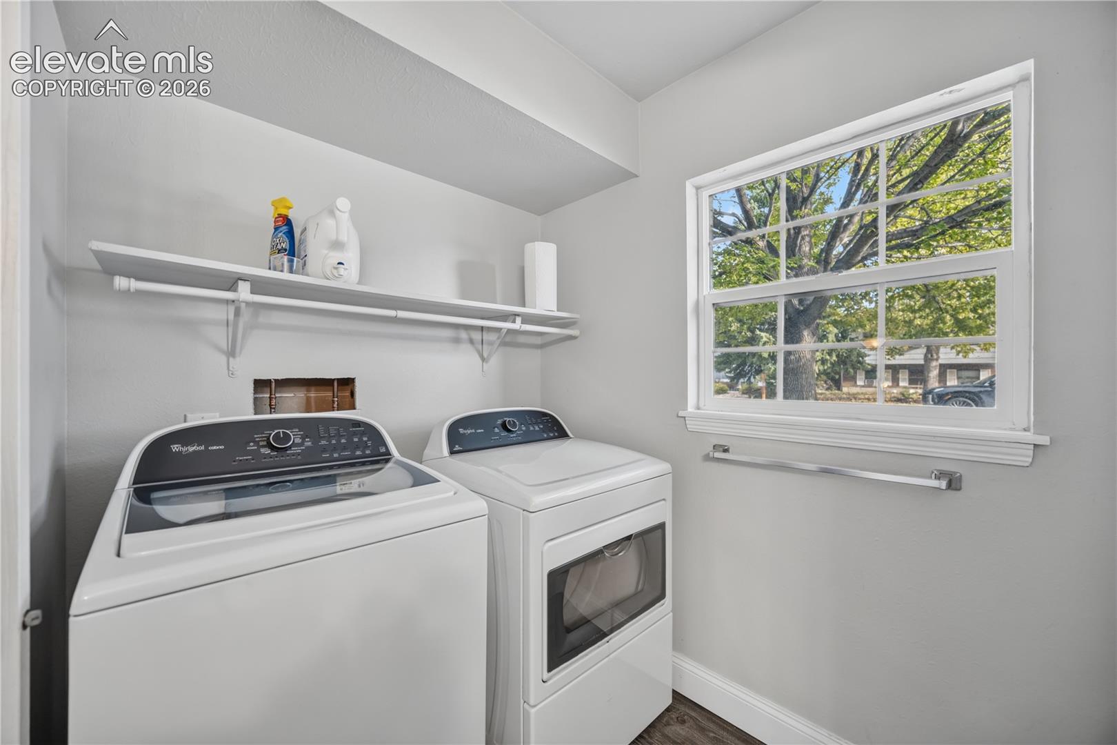 Laundry area featuring a multi-pane window, built-in shelving, and a wall-mounted towel bar