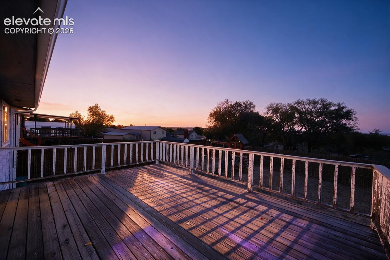 Expansive wood-plank deck with a white painted railing