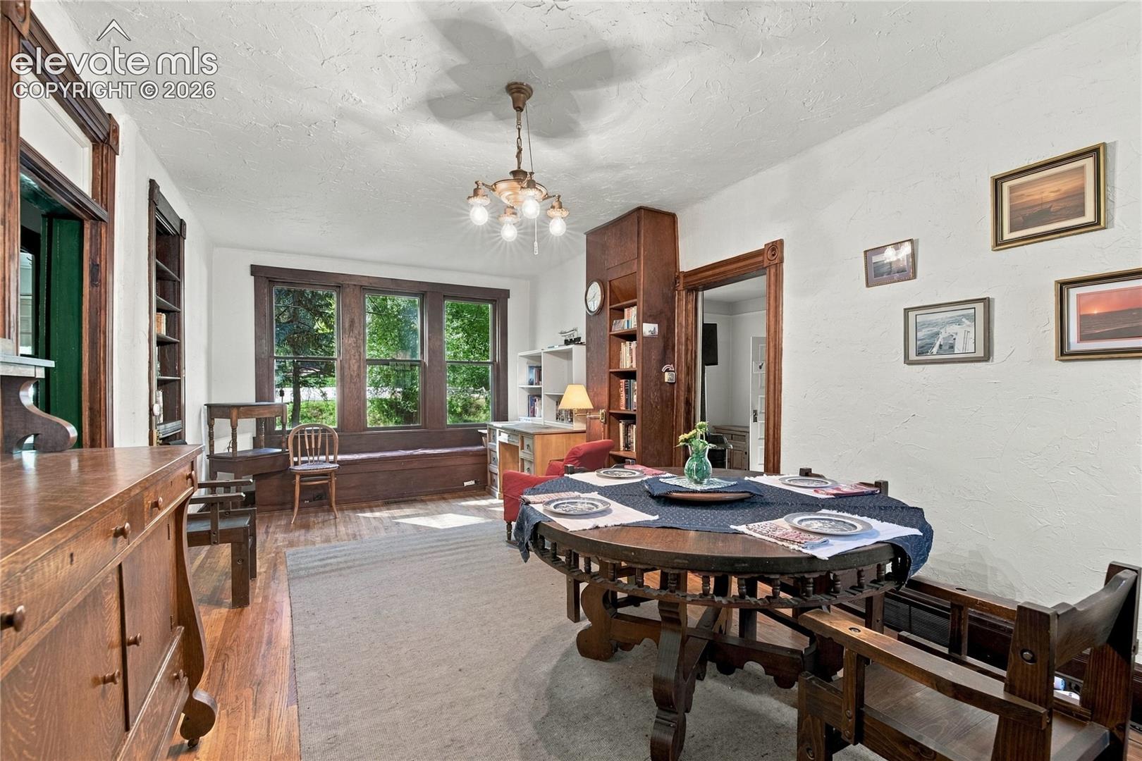 Large dining area and sitting room with large windows and built in shelving.