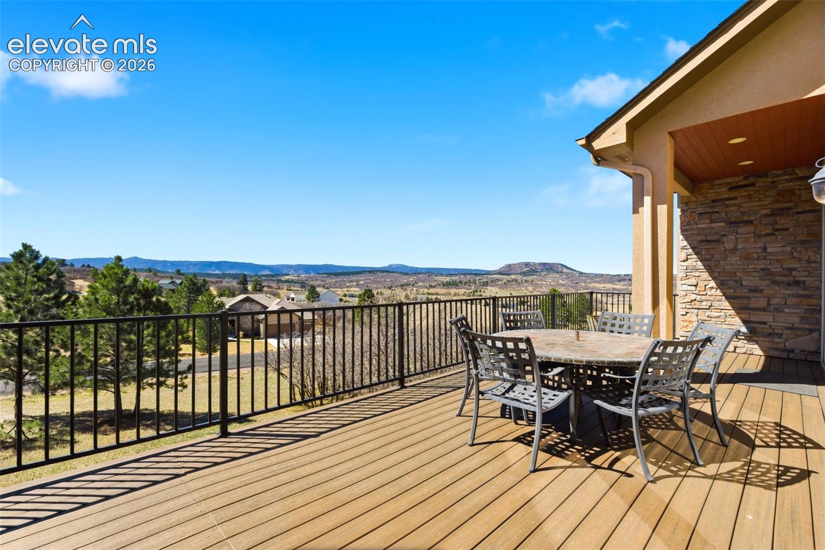 Expansive outdoor deck featuring wood-finish flooring and black metal railings