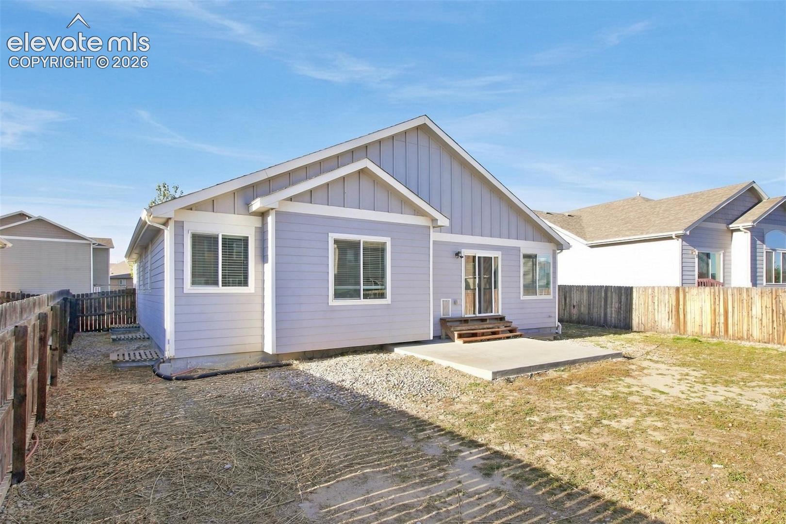 Exterior featuring horizontal and vertical lap siding, a concrete patio, and a wood privacy fence