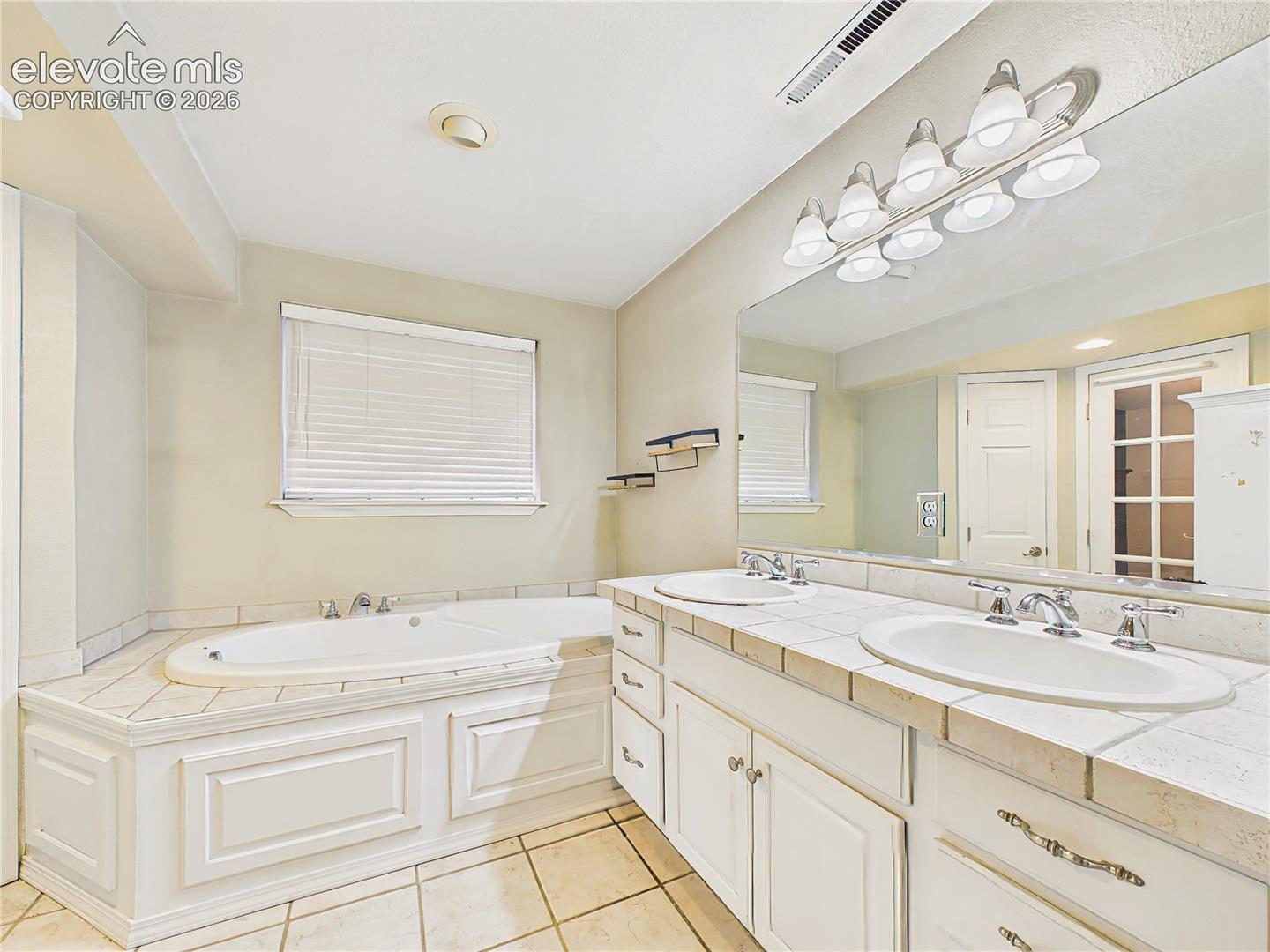 Well-appointed primary bathroom with dual sinks, generous vanity space, and a relaxing soaking tub. Lower Level