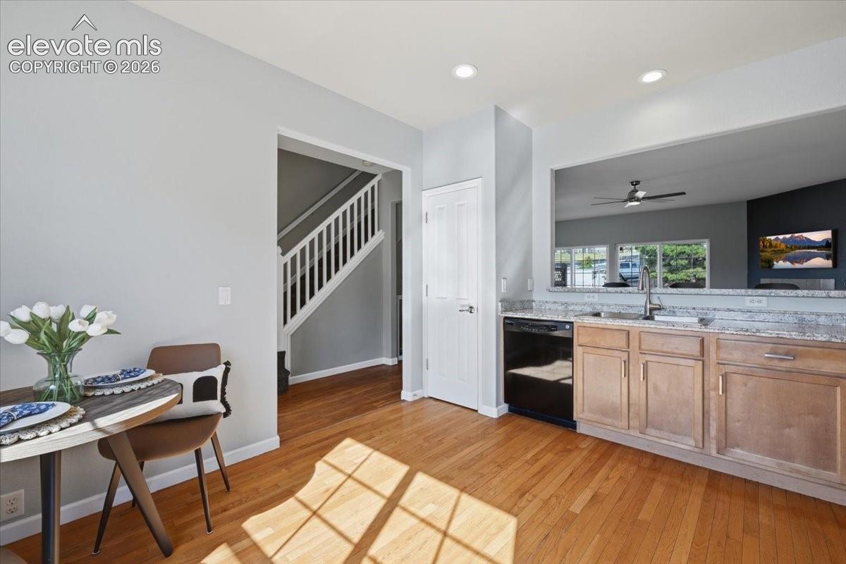 Hardwood flooring, light gray wall paint, white trim, open pass-through, and built in pantry