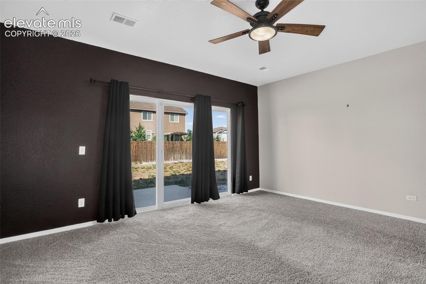 Sliding glass doors, wood-finish ceiling fan with lighting, and plush carpeting
