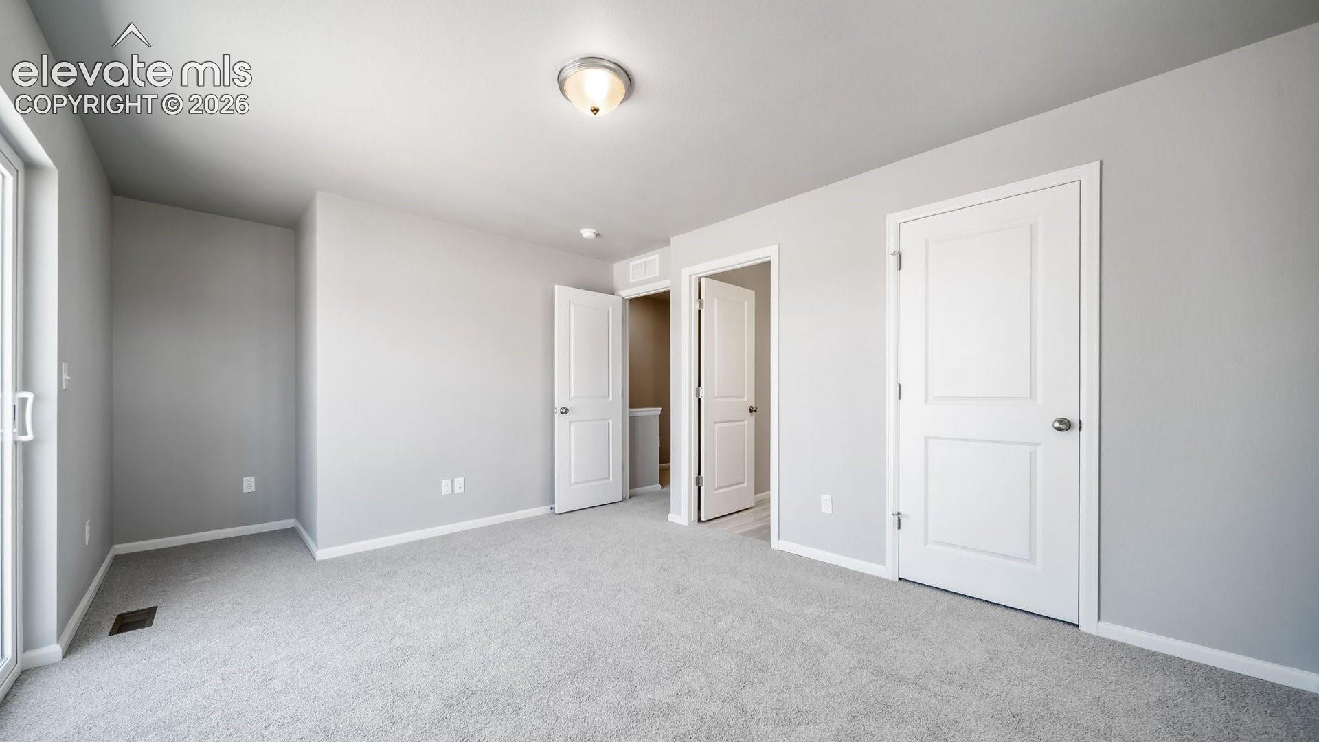 Neutral-toned interior featuring wall-to-wall carpeting, crisp paint finishes, two-panel interior doors, and a sliding glass door
*photos of a model home*