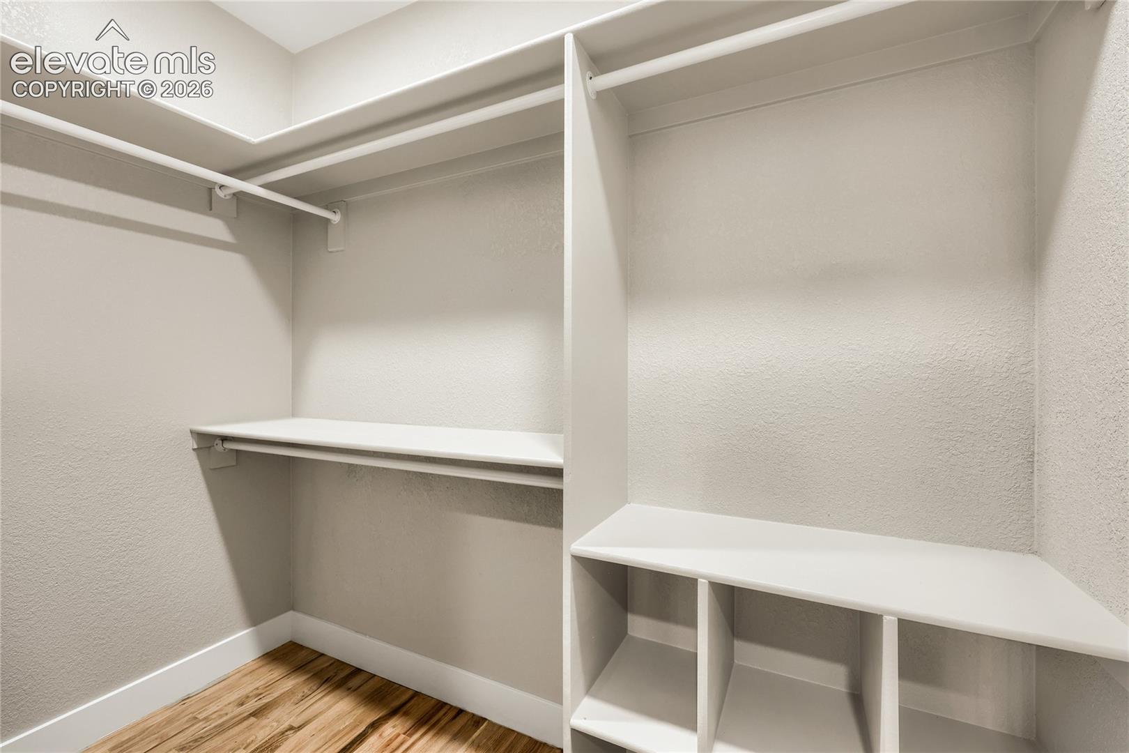 Walk-in closet in the primary bedroom, with built-in shelving for the closet organizer.