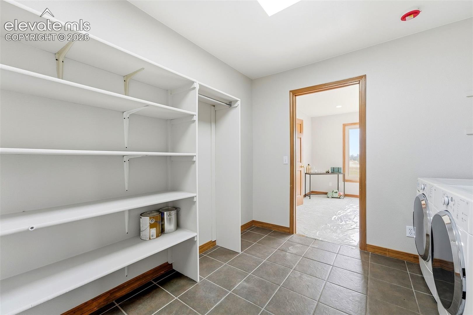 Built-in shelving, tile flooring, wood-finish trim, and skylight