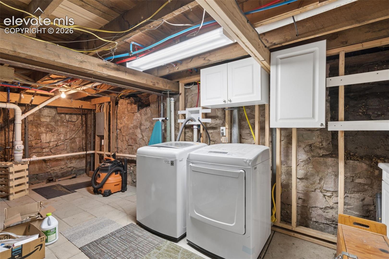 Laundry area in basement with 2 built in cabinets