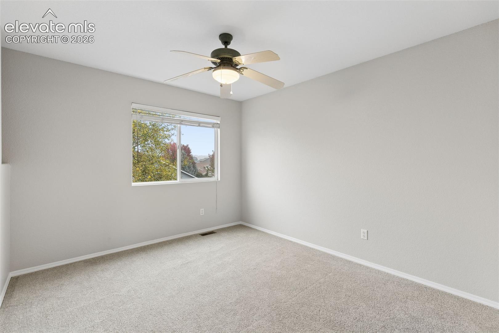 Neutral wall palette with carpeted flooring, a ceiling fan with integrated lighting, and a window with horizontal blinds