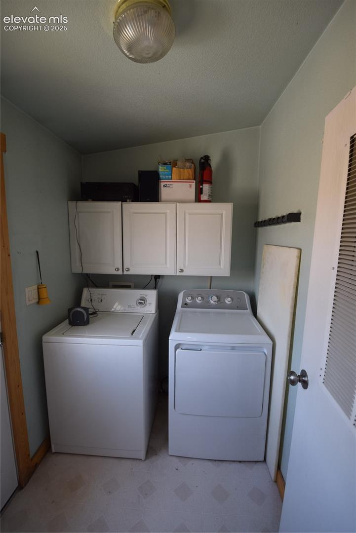 Laundry area featuring white cabinetry and light-toned flooring
