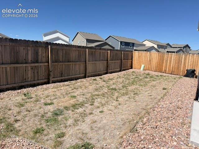 Fully fenced backyard with wood fencing and a gravel perimeter