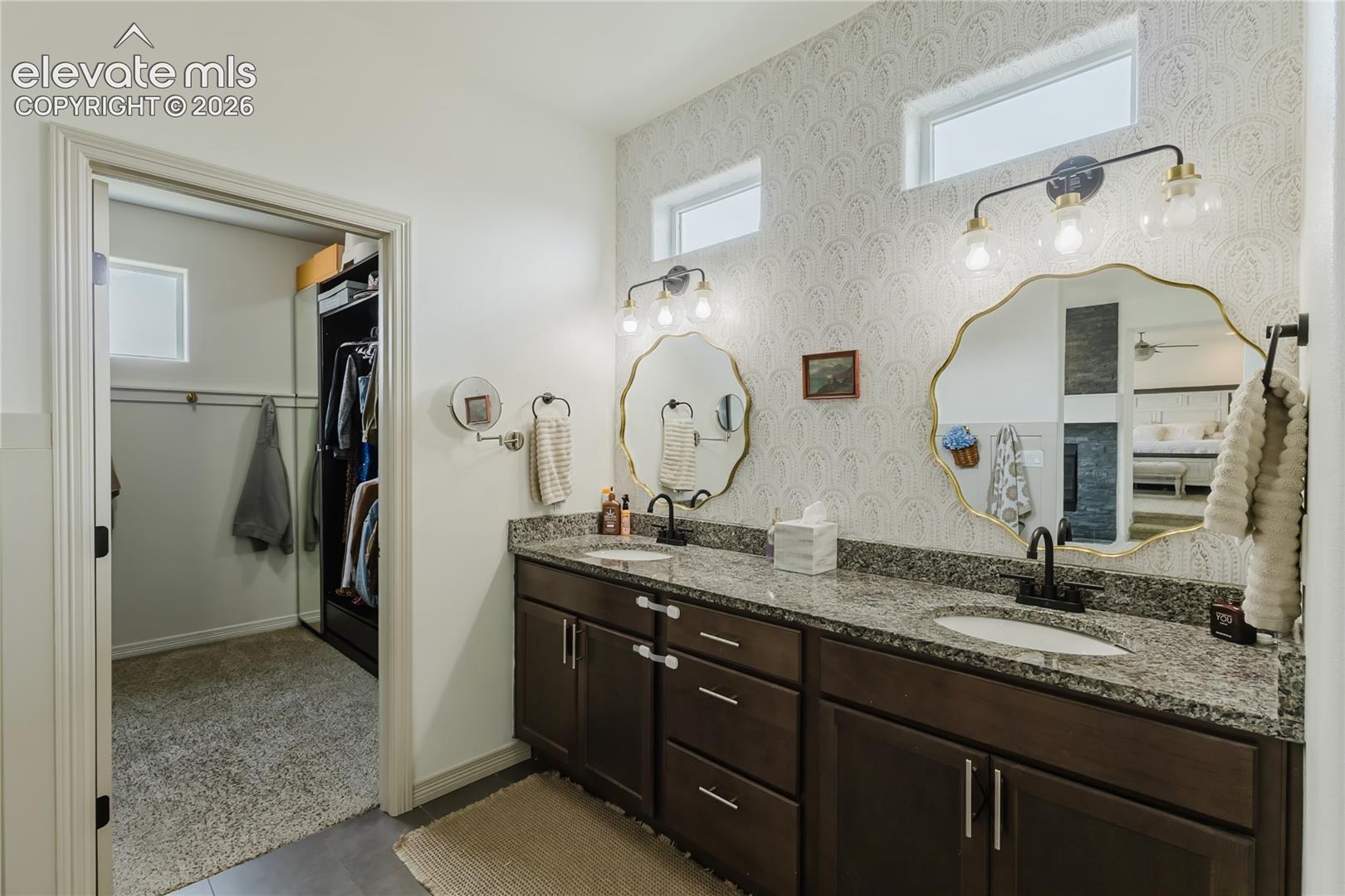 Double vanity featuring granite countertops, undermount sinks, and matte black fixtures