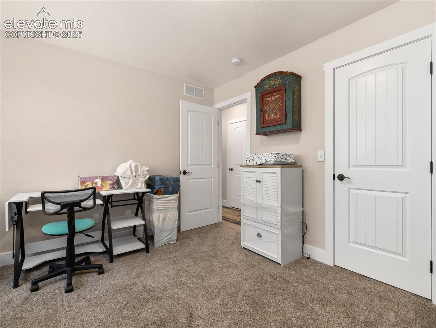 Soft neutral wall color, plush carpet flooring, white trim, and white paneled doors