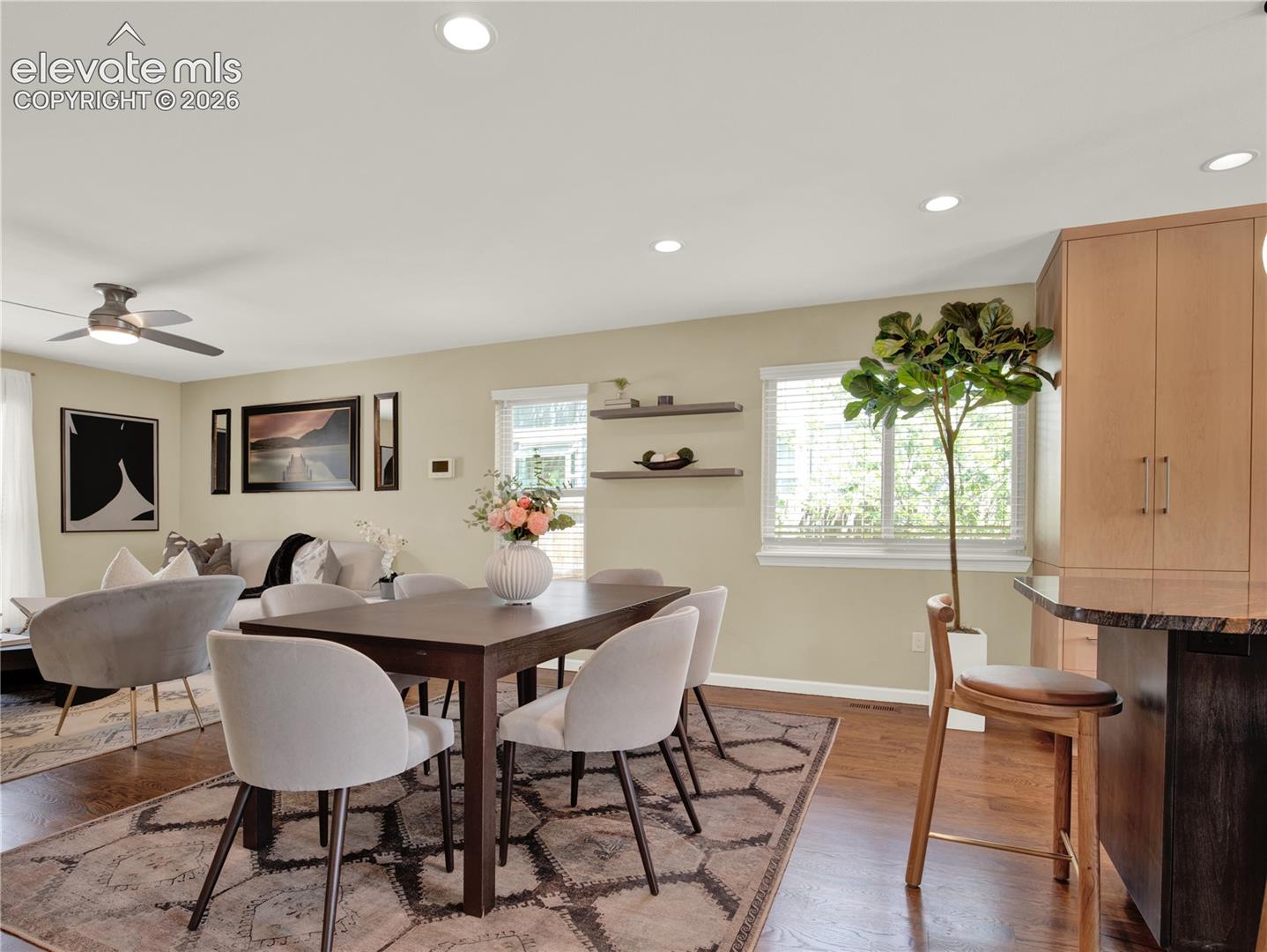 Wood-finish flooring, recessed lighting, built-in cabinetry, breakfast bar, and wall-mounted shelving