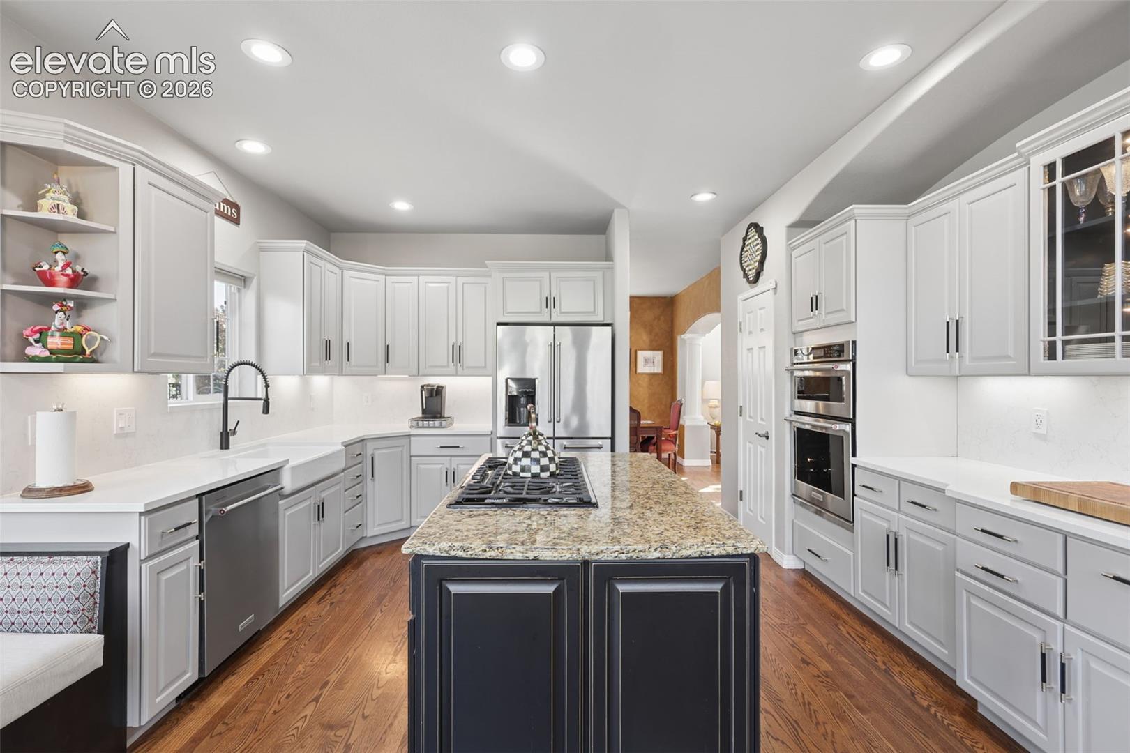 Beautifully remodeled gourmet kitchen with granite, quartz, wood floors, island, and high-end appliances.
