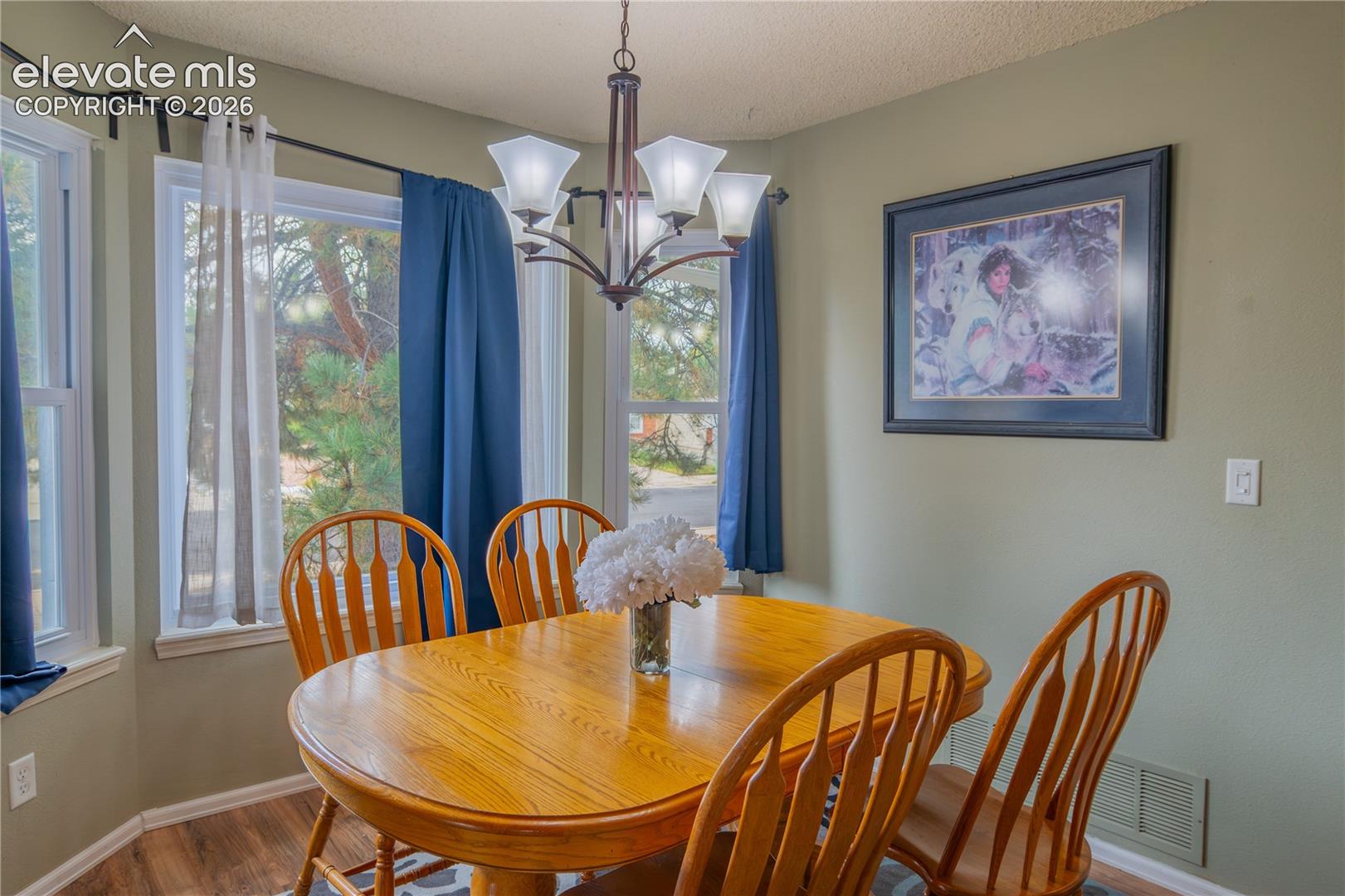 Bay window, wood-finish flooring, recessed lighting, chandelier, neutral wall color