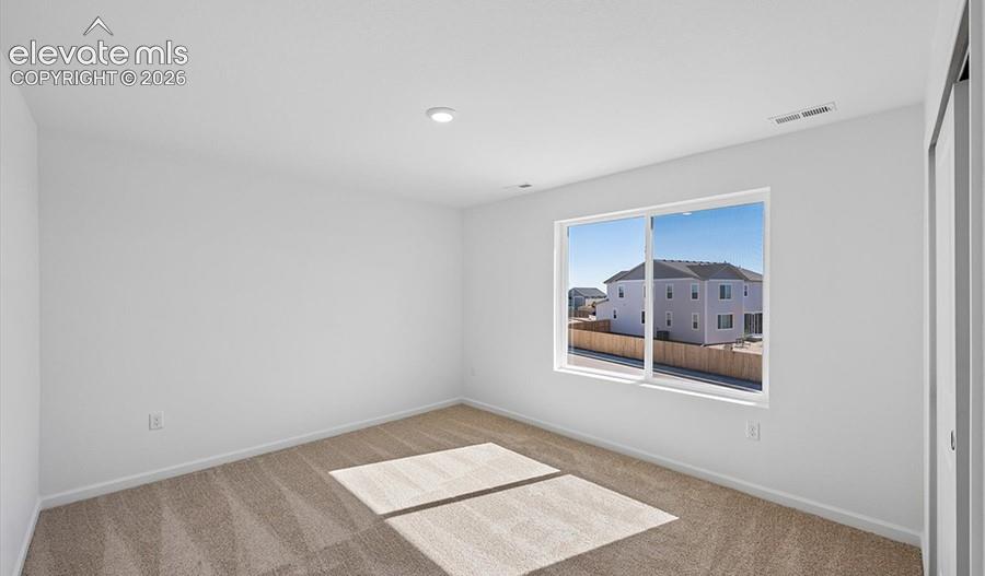 Neutral-toned walls, high-profile carpeting, recessed lighting, and a sliding window with exterior exposure