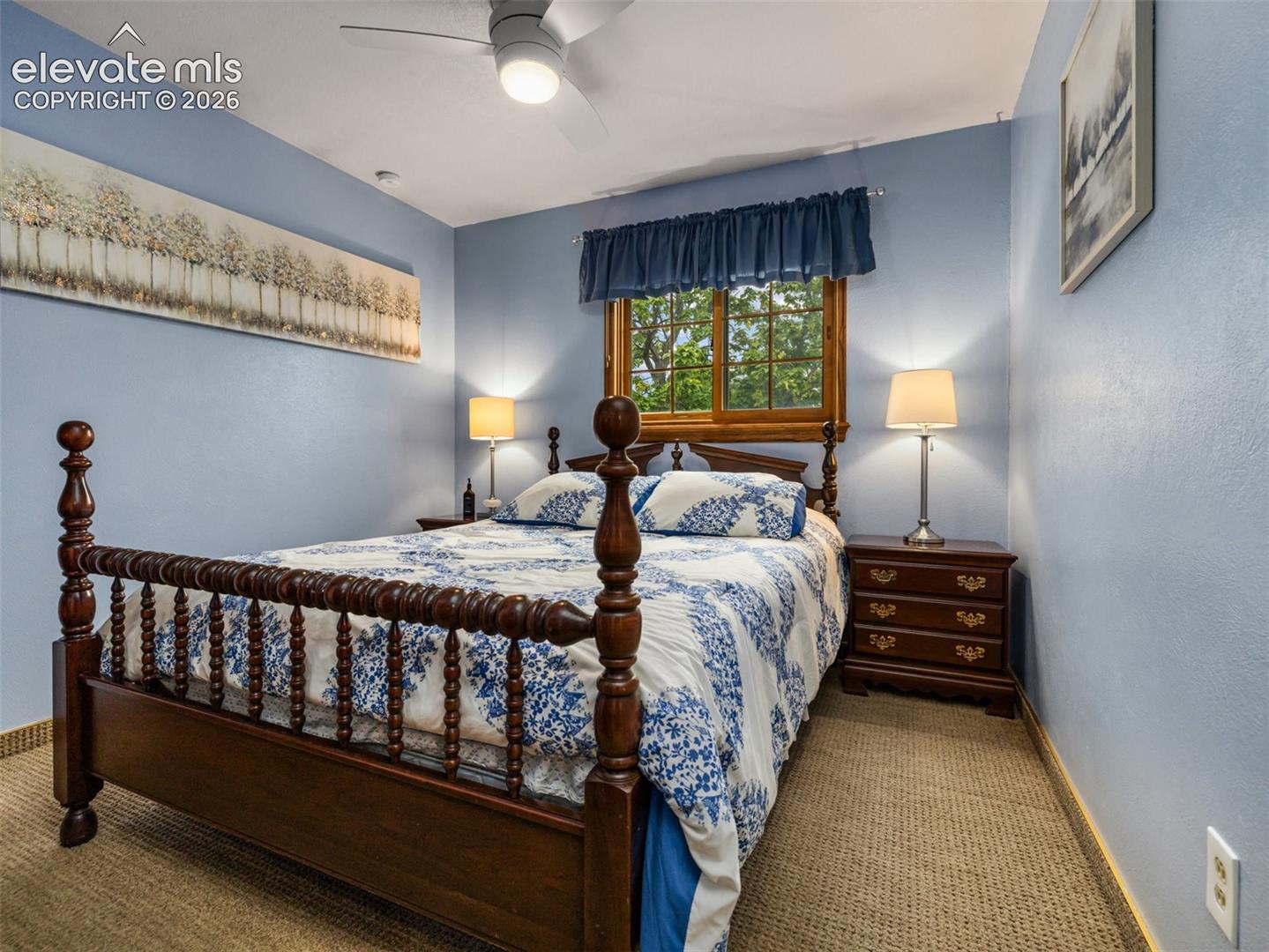 Carpeted flooring with a wood window frame, a built-in ceiling fan with integrated lighting, and painted walls